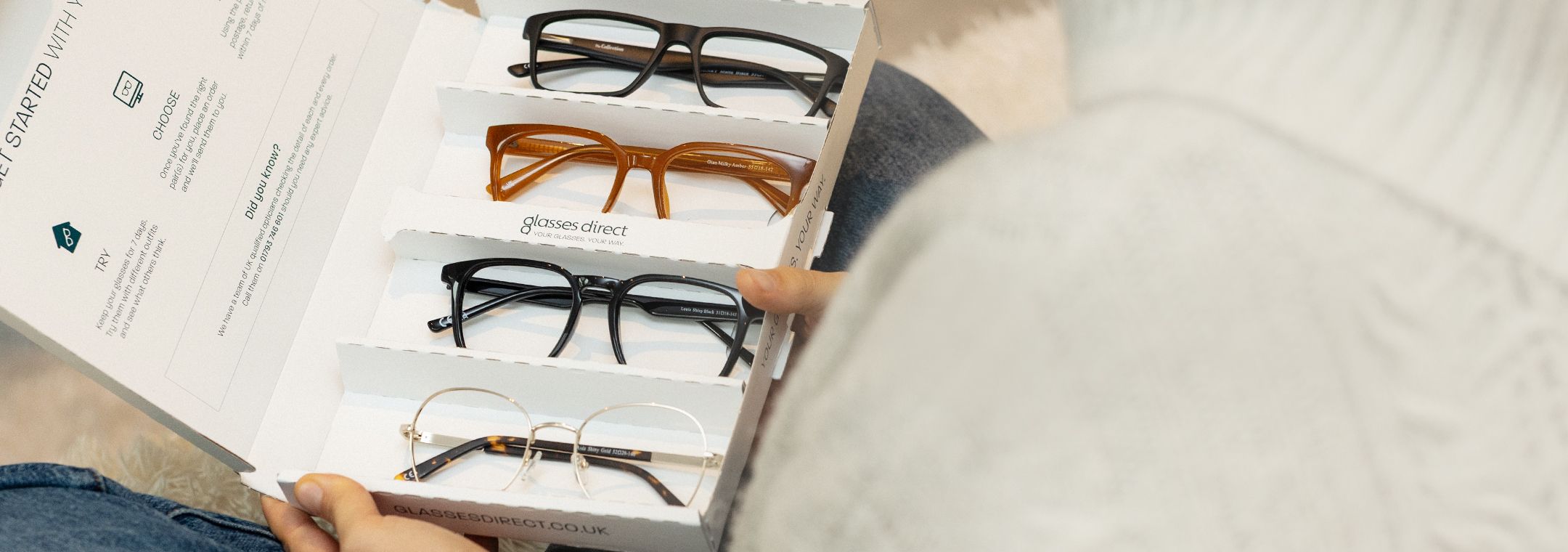 Woman holding her Free home trial box with 4 pairs of frames