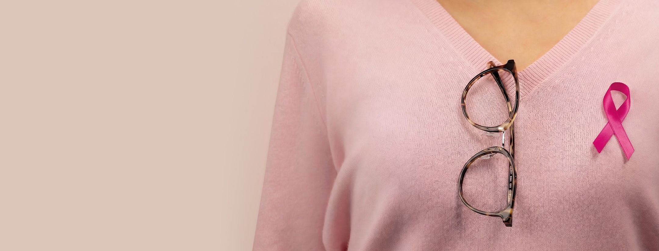 Pair of Pink Ribbons frames hanging from woman's jumper